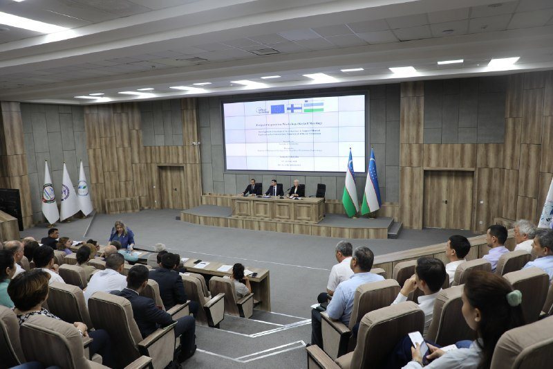 Participants in a lecture hall, with the EU, Finnish and Uzbek flags on the screen