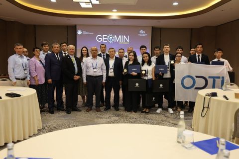 Участники и организаторы хакатона на фоне экрана конференции GEOMIN