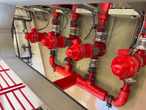 Red pumps and pipework inside a pumping station