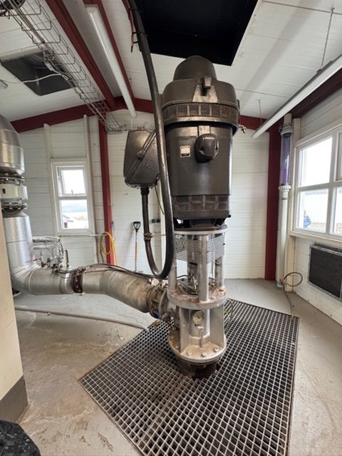 A wellhead pump inside a small well house