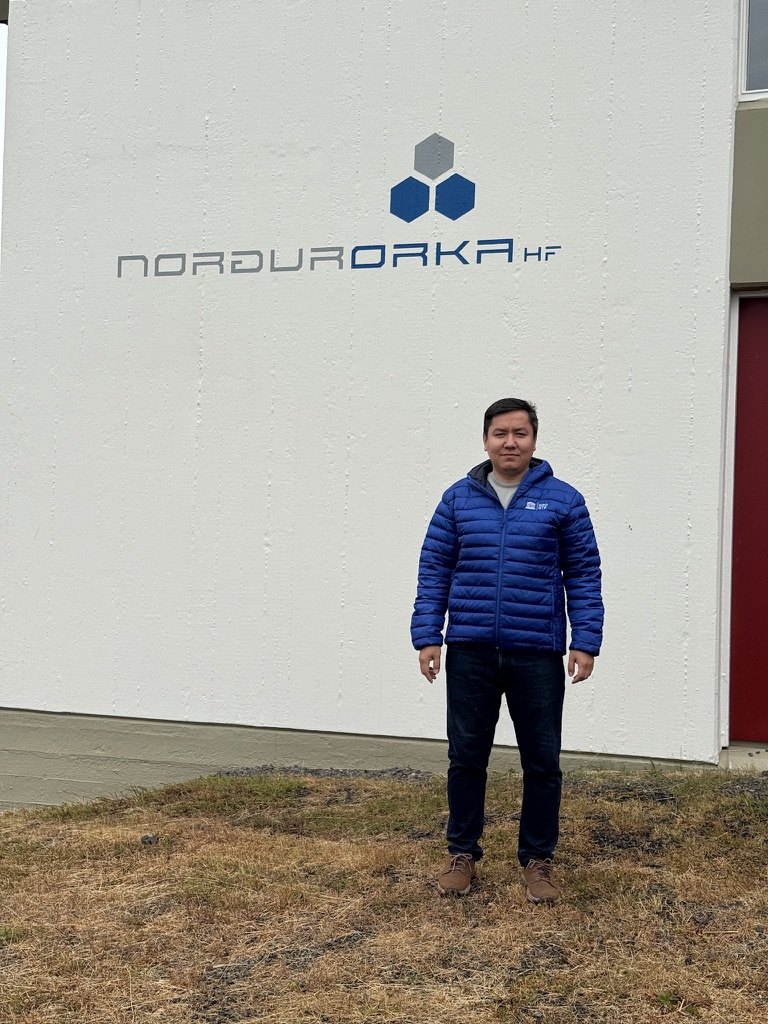 Elbek Ochilov standing in front of a white building with the Norðurorka logo
