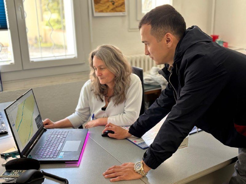 A trainee and a hydrogeologist looking at a map on a laptop