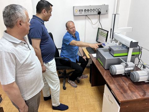 Three men at the Picarro analyser in the new laboratory; one, seated, points at the computer screen