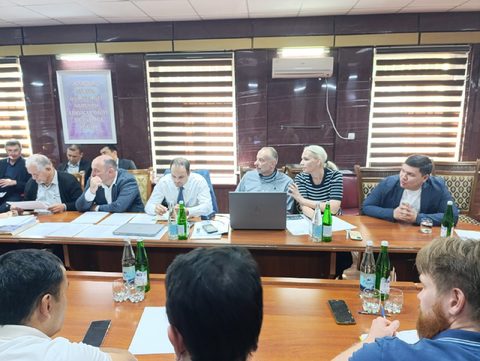 Специалисты с ноутбуками за столом переговоров